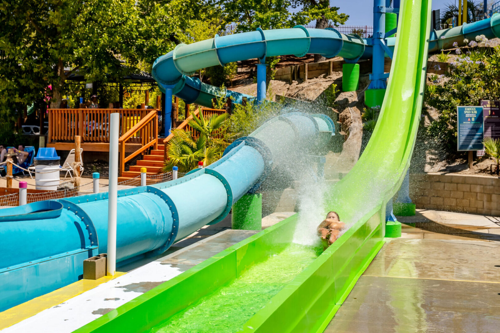 Person sliding down bright green water slide