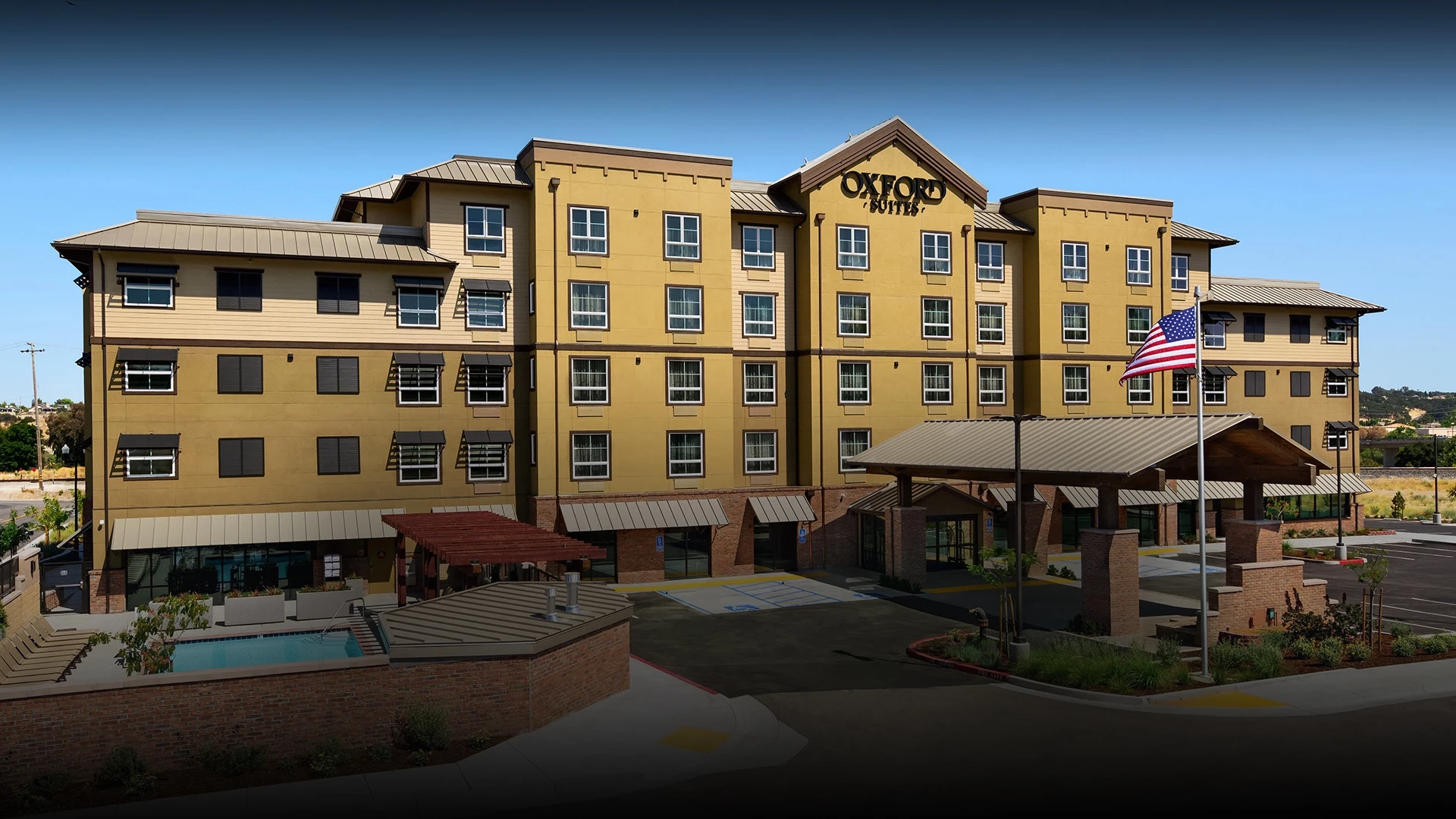 Modern yellow apartment complex with multiple floors and balconies.