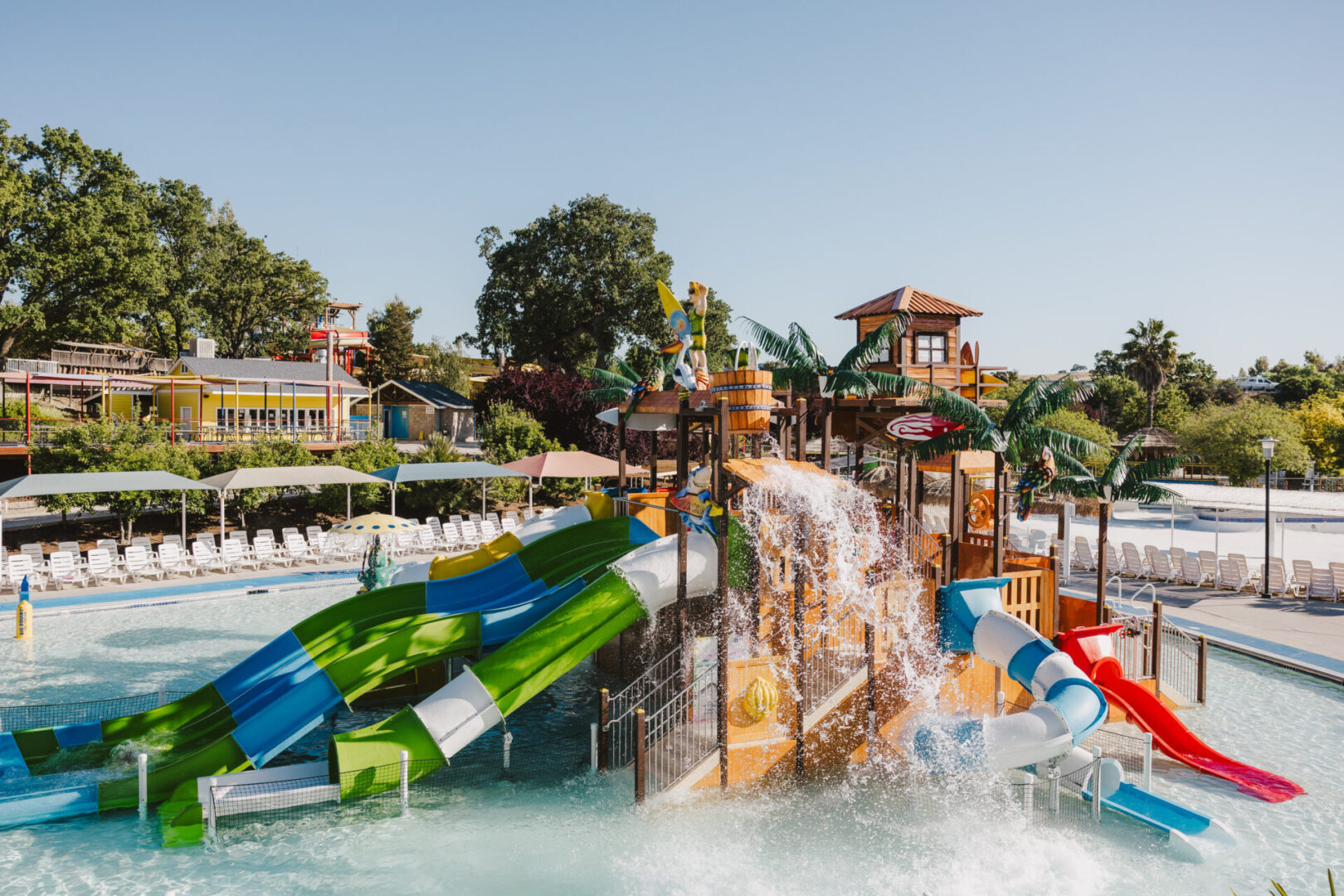 Water park with colorful slides and splash zones under a clear sky.